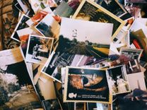 Assorted collection of vintage photographs scattered on a table, suggesting nostalgia or historical research.